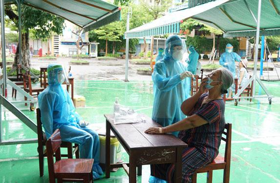 Nhân viên y tế lấy mẫu xét nghiệm cho người dân vào sáng 31-7 ở khu vực gần 3 bệnh viện tại Đà Nẵng bị phong tỏa. Ảnh: ANH PHIỆT