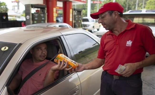 Tuy nhiên, kinh tế Venezuela đang lao dốc với mức lạm phát cao đến mức người dân ở đây không còn dùng tiền để đổ xăng, mà đổi bằng thực phẩm, kẹo hay thậm chí là một điếu thuốc lá.
