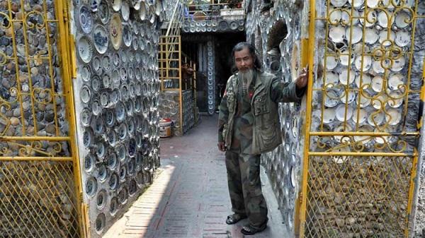 Ông Nguyễn Văn Trường bên căn nhà được trang trí bằng gần 10.000 bát đĩa cổ của mình.