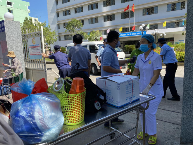 Nữ điều dưỡng dùng xe đẩy hành lý của bệnh nhân ra ngoài