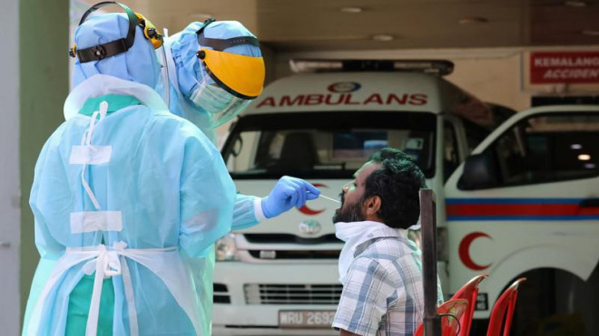 Nhân viên y tế xét nghiệm một người nghi nhiễm COVID-19 tại bệnh viện&nbsp;KPJ Damansara thuộc TP&nbsp;Petaling Jaya, Malaysia vào tháng 3. Ảnh: AP