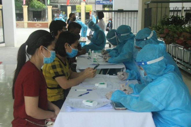 Ngành y tế Hà Nội lấy mẫu xét nghiệm cho những người trở về từ Đà Nẵng. Ảnh: HP