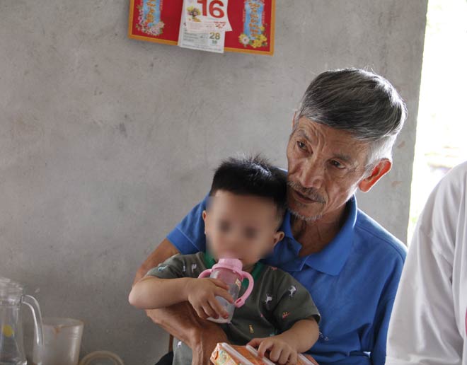 Ông Minh bế con út của chị N. mới 18 tháng tuổi.