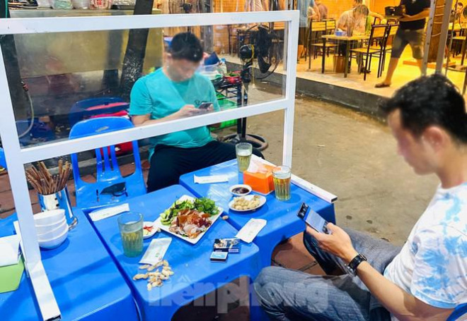 Vách ngăn tự chế được thiết kế 2 tầng với lớp chắn phía trên làm bằng mica và khoảng hở bên dưới để khách hàng có thể cụng ly cùng với nhau.