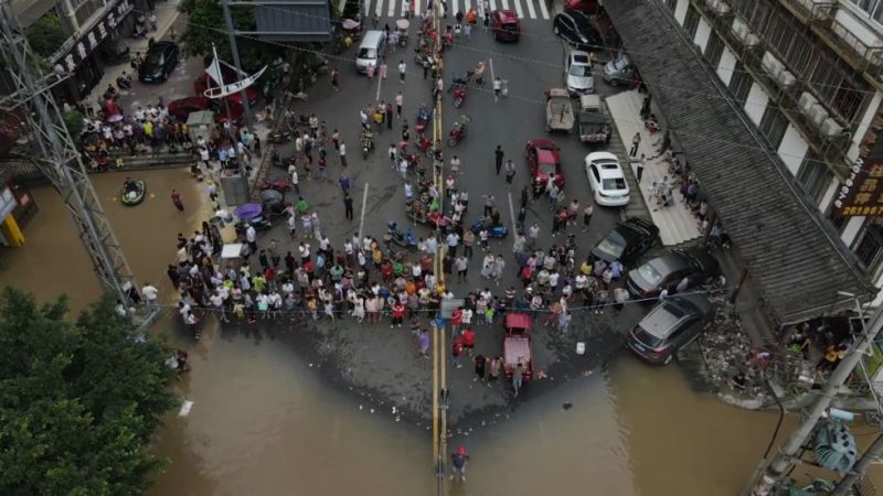 Người dân Trung Quốc quay lại dọn dẹp đường phố trong khi nước lũ còn chưa rút hết (ảnh: Xinhua)
