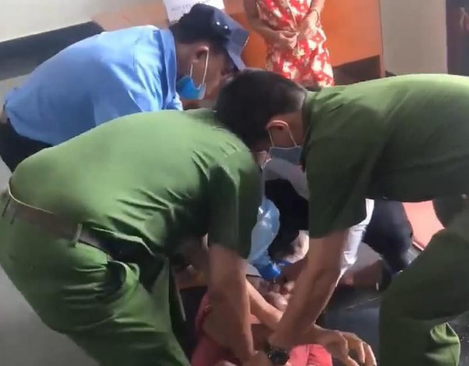 Lực lượng công an sơ cứu cho bị án nghi uống thuốc sâu tại tòa. Ảnh: Người dân cung cấp