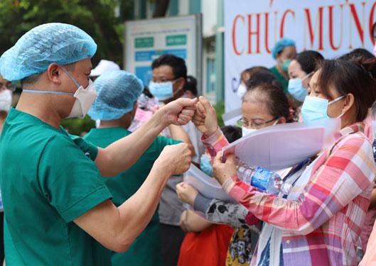 Bác sĩ Bệnh viện Dã chiến Hòa Vang chia vui với bệnh nhân trước khi xuất viện. Ảnh: BÍCH VÂN
