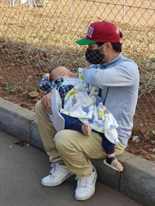 Cháu bé cùng bố đang đợi làm thủ tục xuất nhập cảnh ở biên giới Mozambique