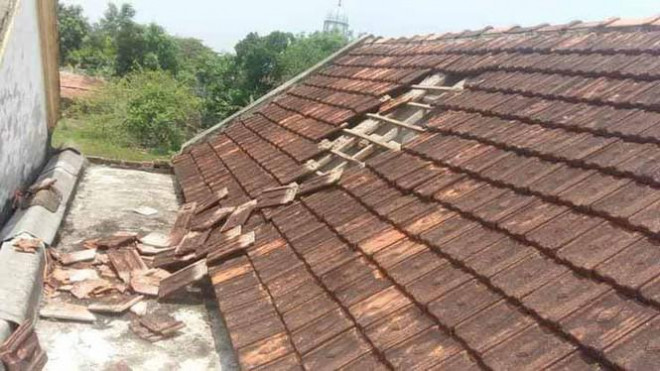 Phần mái ngói nhà bà Mai bị máy bay làm tốc mái.