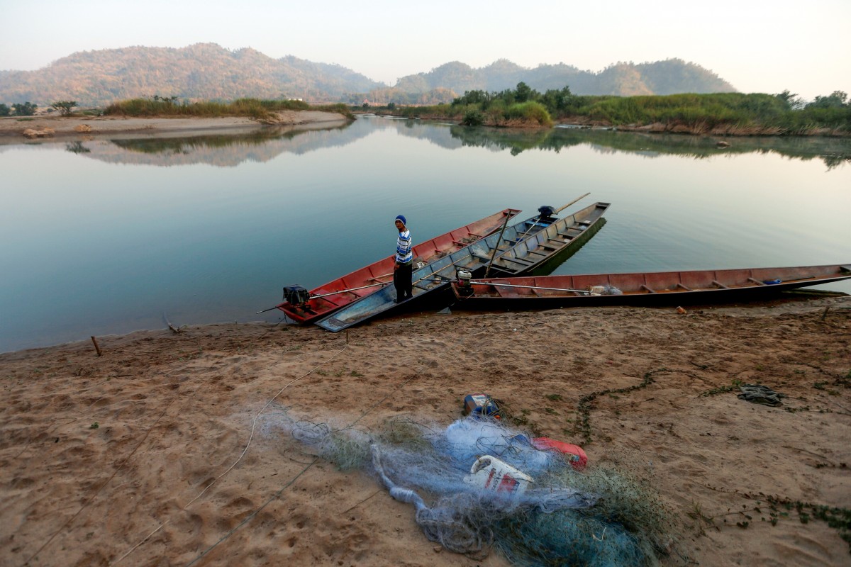 Một ngư dân đứng bên bờ sông Mekong.