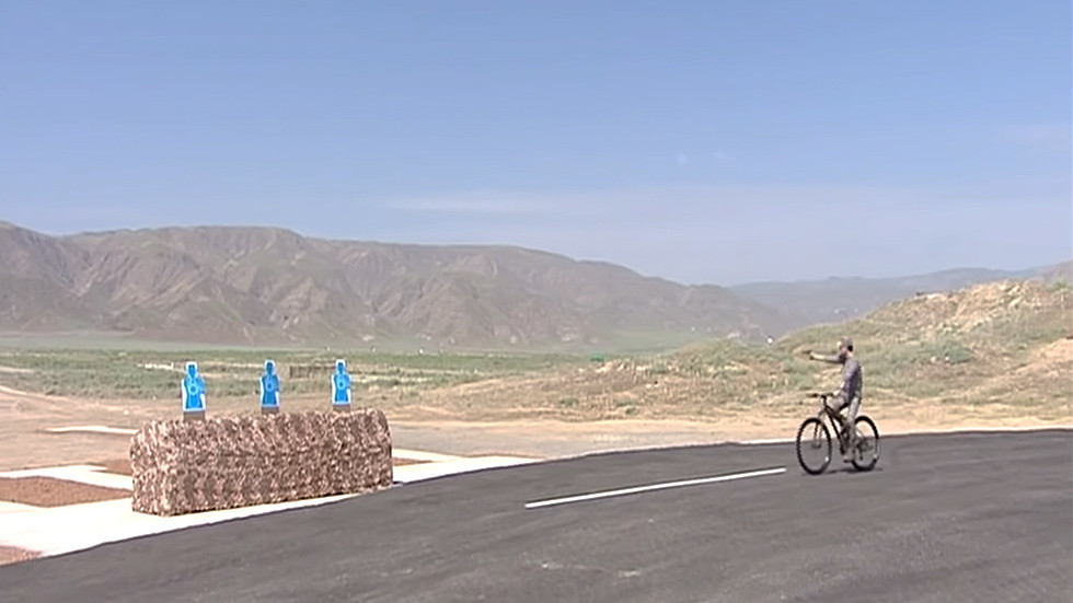 Tổng thống Turkmenistan một tay đạp xe, một tay bắn súng ngắn.