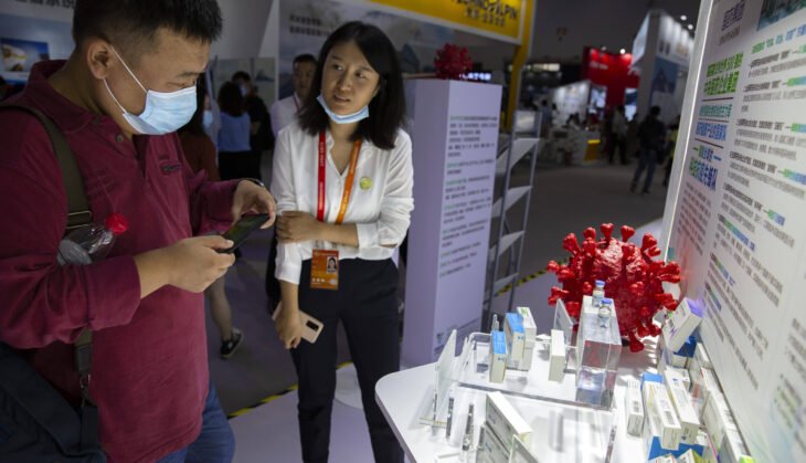 Một khách tham quan xem mô hình về virus Corona và các bộ vaccine Covid-19 tại buổi trưng bày của hãng dược phẩm Trung Quốc Sinopharm tại Hội chợ thương mại dịch vụ quốc tế Trung Quốc ở Bắc Kinh hôm 5/9. Ảnh: AP