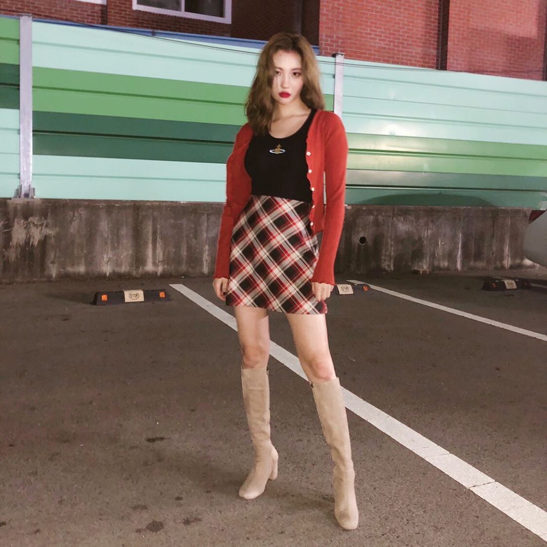 Trong set đồ này, Sunmi chọn kết hợp áo ôm sát màu đen với chân váy caro, khoác ngoài cardigan ngắn cùng với đó là đôi boots cao cổ màu nude. Màu sắc này cũng có hiệu quả trong việc giúp bạn nhìn cao hơn thực tế.