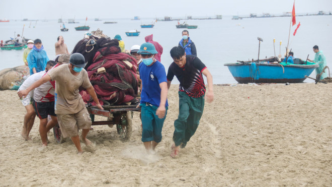 Lực lượng dân quân phường Thọ Quang, Sơn Trà giúp đỡ ngư dân đưa ngư lưới cụ lên bờ. Ảnh: Nguyễn Thành.&nbsp;