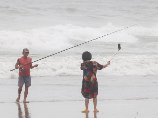 Mặc sóng lớn sau bão, người dân vẫn ra biển câu cá, chụp hình