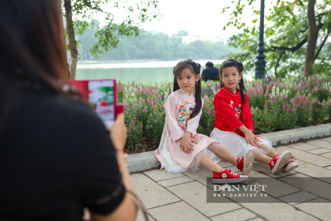 Nhiều người tỏ ra bất ngờ khi trông thấy những bồn hoa mới ven bờ hồ Hoàn Kiếm, vội dừng lại chụp ảnh kỉ niệm cùng người thân, bạn bè.