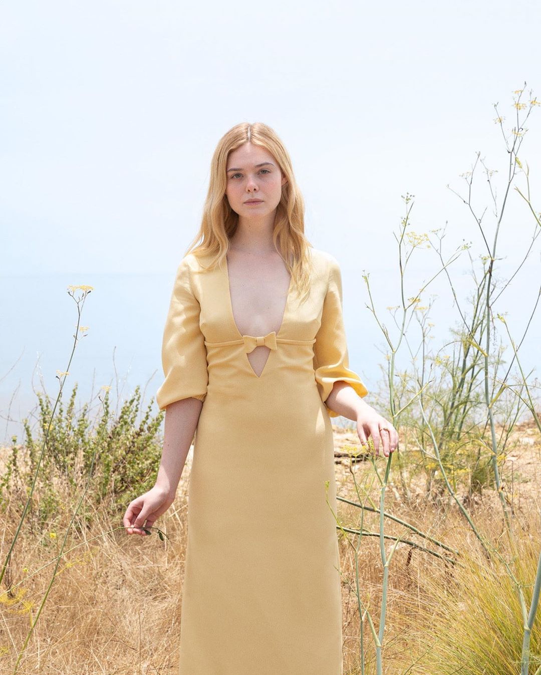 Lần này, Elle Fanning chọn diện thiết kế của Miu Miu. Chiếc váy&nbsp;dáng suông màu vàng được thiết kế tinh giản chứ&nbsp;không&nbsp;đơn điệu. Điểm nhấn của bộ trang phục là kiểu dáng cổ chữ V khoét sâu với chi tiết thắt nơ&nbsp;tôn vòng một nhỏ nhưng sang của Elle Fanning. Ngoài ra, người đẹp còn đeo thêm&nbsp;chiếc nhẫn của&nbsp;Cartier.