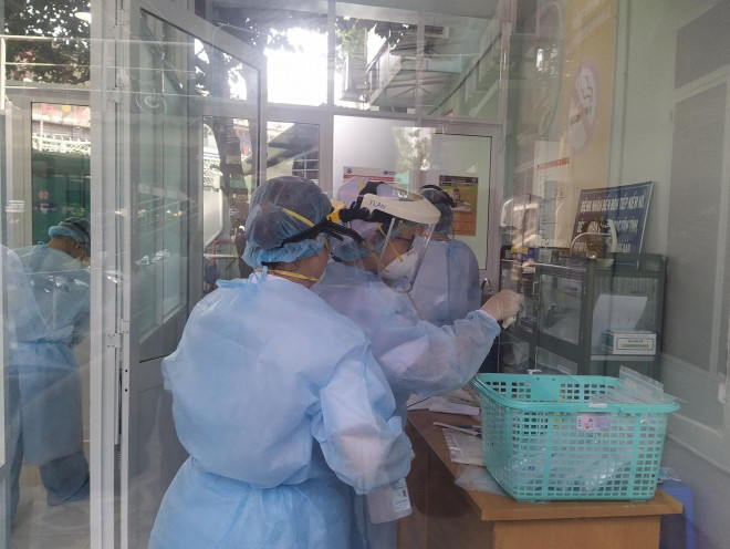 Nhân viên y tế làm việc tại đơn vị sàng lọc ở gần cổng Bệnh viện Nhi Đồng 1