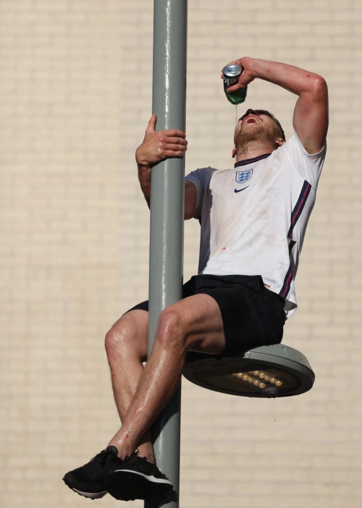 Một fan "cuồng" trèo
lên cột đèn đường uống bia, ăn mừng thời khắc lịch sử cùng
bóng đá Anh