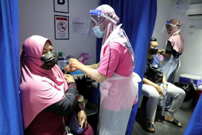 Nhân viên y tế Malaysia tiến hành tiêm ngừa COVID-19 cho người dân. Ảnh: REUTERS