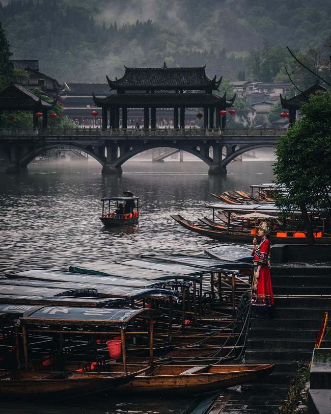 Một con thuyền gỗ nhỏ, nhẹ nhàng trôi hờ hững sau một trận mưa như trút nước tại Phượng Hoàng Cổ Trấn, Trung Quốc.
