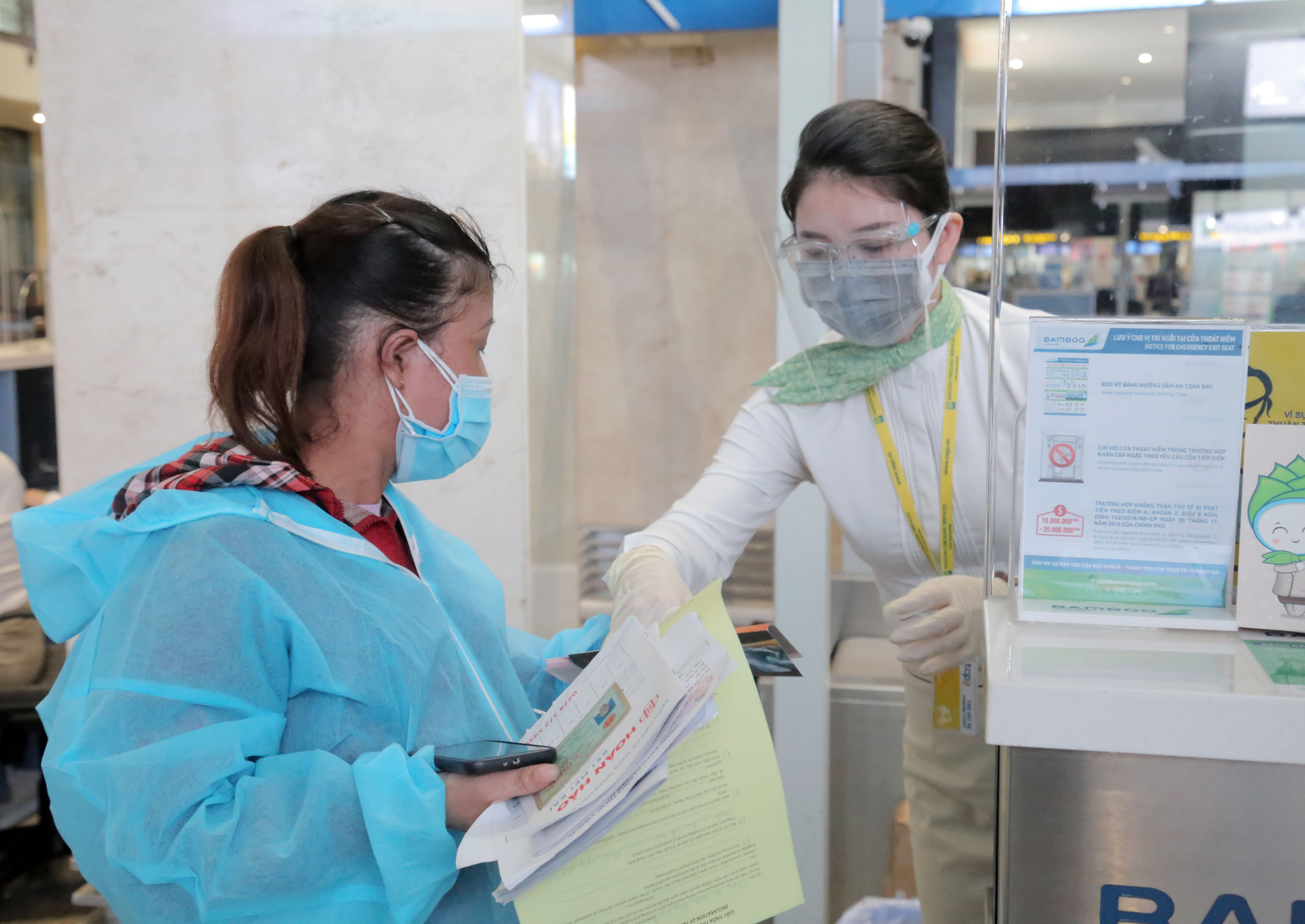 Nhân viên hãng bay hướng dẫn các thủ tục cần thiết cho hành khách trước khi lên tàu bay.&nbsp;Người dân Bình Định có hoàn cảnh đặc biệt khó khăn đang ở TP.HCM muốn về quê có thể liên lạc với Hội đồng hương Bình Định tại TP.HCM để được hướng dẫn thực hiện các thủ tục đăng ký.