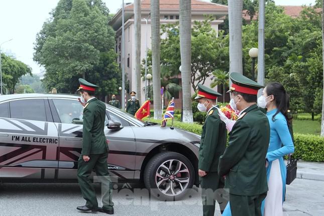 Sĩ quan an ninh Quân đội nhân dân Việt Nam tiếp cận, mở cửa xe cho Bộ trưởng Quốc phòng Liên hiệp Vương quốc Anh và Bắc Ai-len. Ảnh: Nguyễn Minh
