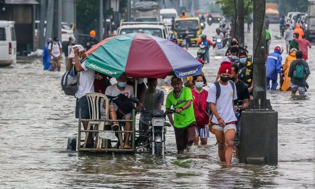 Người dân lội qua dòng nước lũ do mưa lớn gió mùa ở tỉnh Rizal, phía Đông thủ đô Manila của Philippines. Ảnh: Shutterstock.
