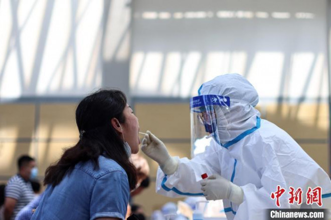 Nhân viên y tế lấy mẫu xét nghiệm ở sân bay Lộc Khẩu, thành phố Nam Kinh, Trung Quốc. Ảnh: China News