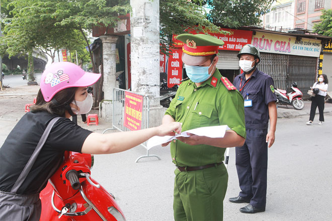 Lực lượng chức năng kiểm tra giấy tờ của người dân tại chốt kiểm soát dịch.