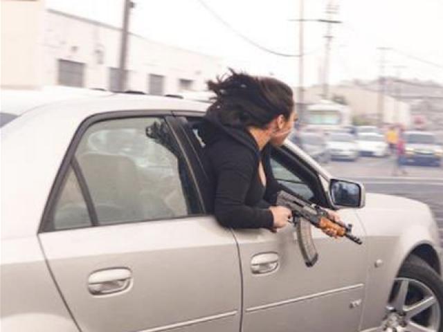 Thế giới - Mỹ: Xôn xao bức ảnh cô gái cầm súng AK-47 nhoài người ra khỏi ô tô như trong chiến tranh