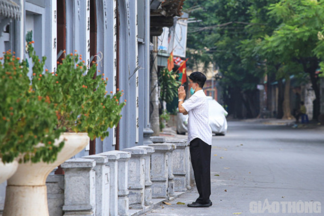 Một người đàn ông còn kéo khẩu trang xuống trong lúc làm lễ.