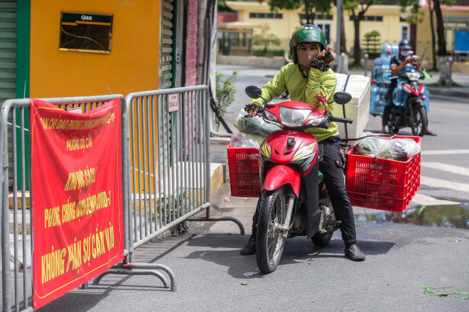Người dân đến giao nhu yếu phẩm phải ở ngoài gọi điện thoại, chờ người bên trong ra nhận.