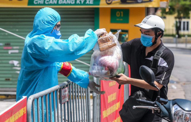 Dân quân tự vệ nhận nhu yếu phẩm của người dân bên ngoài gửi vào khu vực phong toả...