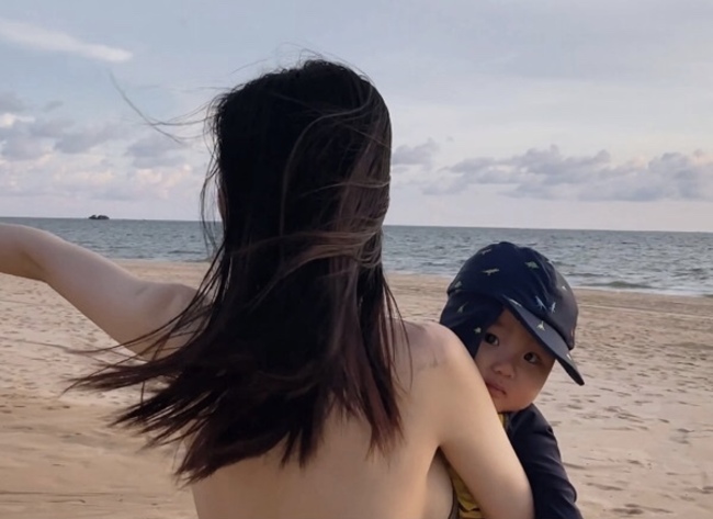 Trong clip, nữ ca sĩ quê Bắc Ninh mặc bikini khoe dáng nóng bỏng, vui đùa cùng con.
