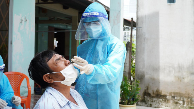 Nhân viên y tế lấy mẫu xét nghiệm tại nhà cho người dân ở Hóc Môn; Ảnh: Huế Xuân