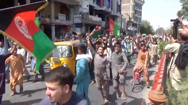 Người dân cầm cờ Afghanistan biểu tình chống Taliban ở TP Jalalabad hôm 18-8 Ảnh: REUTERS