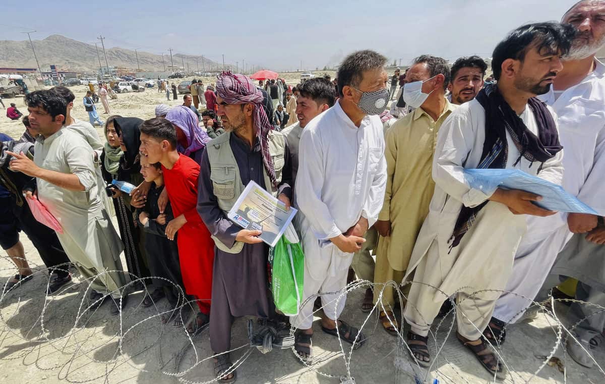 Một người đàn ông cầm chứng chỉ xác nhận làm việc cho Mỹ tại Afghanistan đứng chờ cùng hàng trăm người khác bên ngoài sân bay quốc tế Kabul hôm 17/8. Ảnh: AP&nbsp;