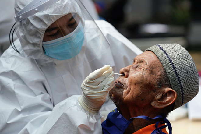 Một nhân viên y tế lấy mẫu xét nghiệm của người đàn ông. Ảnh: Reuters