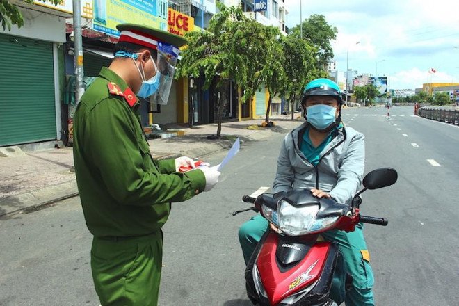 Chốt kiểm soát Phan Văn Trị - Phạm Văn Đồng kiểm tra giấy đi đường của người dân. Ảnh: LÊ THOA