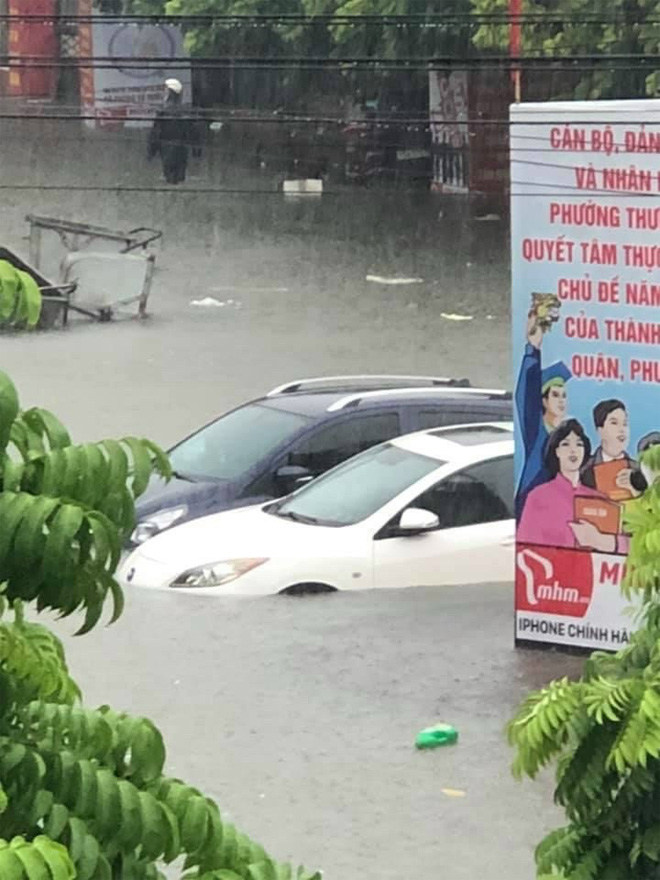  Một số ô tô đỗ ven đường chỉ sau một đêm nước đã ngập quá bánh, không thể di chuyển.