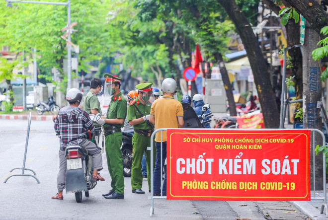 Tổ công tác đặc biệt tại ngã tư phố Phùng Hưng giao nhau với phố Hàng Bông, đang thực hiện nhiệm vụ kiểm tra giấy đi đường của người dân