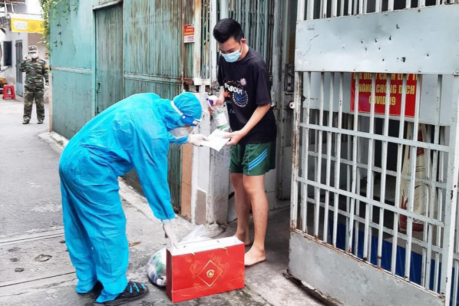 Cán bộ phường 5, quận Tân Bình trao thuốc, thực phẩm cho F0 đang điều trị tại nhà. Ảnh: NH Phường đang cố gắng khắc phục để hỗ trợ người dân