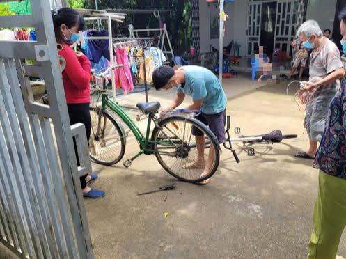 Người dân hỗ trợ sửa lại xe đạp cho Đại