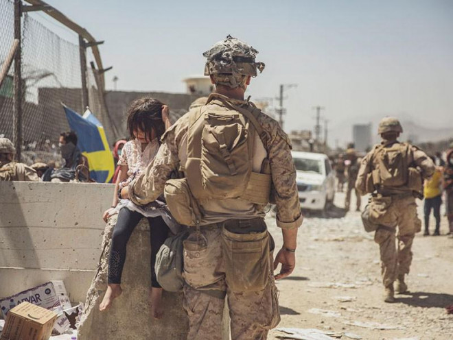 Binh sĩ Mỹ chăm sóc một bé gái Afghanistan ở sân bay Kabul ngay sau vụ đánh bom ngày 26-8.&nbsp;Ảnh: AP