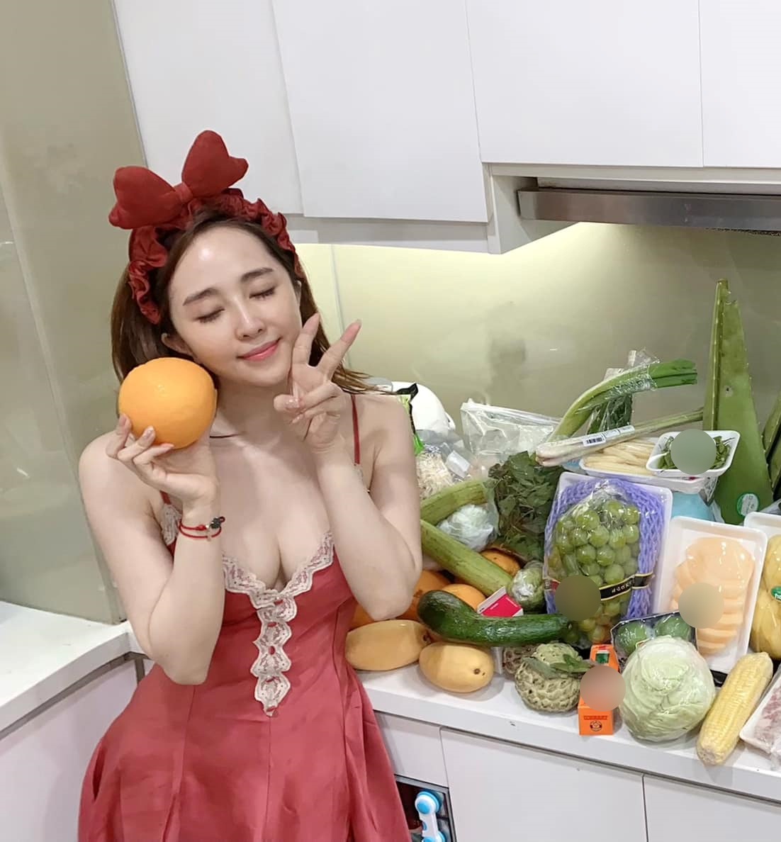Quỳnh Nga chọn mặc thiết kế váy lụa hai dây tôn vòng 1 chụp hình trong bếp.