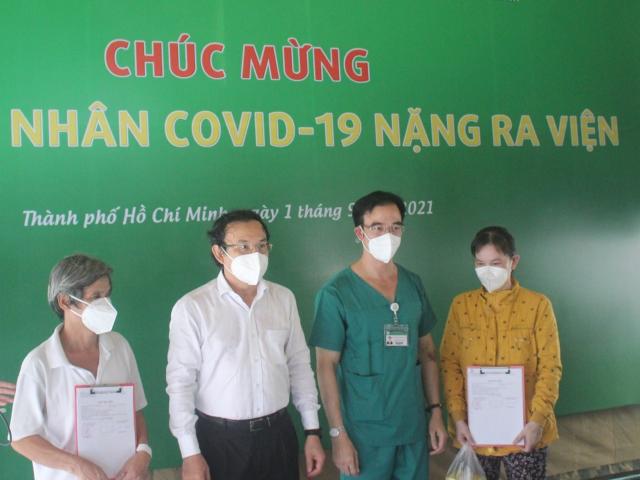 Bí thư Thành ủy TP.HCM Nguyễn Văn Nên và GS.TS Nguyễn Quang Tuấn chụp ảnh chung với các bệnh nhân được xuất viện. (Ảnh: Hà Văn Đạo)