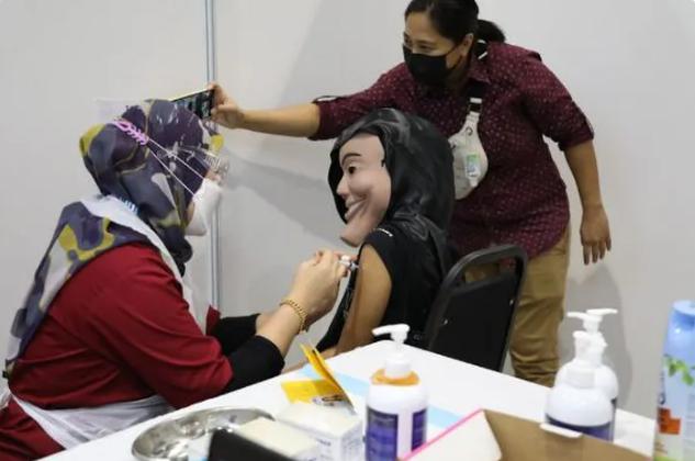 Hình ảnh một cô gái đeo mặt nạ đi tiêm chủng khiến dân mạng không khỏi tò mò.