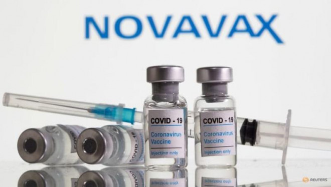 Các lọ vaccine ngừa COVID-19 xếp phía trước logo tập đoàn công nghệ sinh học Mỹ Novavax. Ảnh: REUTERS