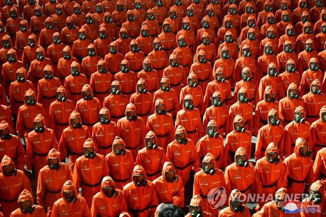 Tờ Rodong Sinmun đã đăng tải bức ảnh chụp những người mặc bộ quần áo bảo hộ màu cam, đeo mặt nạ phòng độc, thể hiện nỗ lực của Triều Tiên trong việc kiểm soát dịch COVID-19. Đến thời điểm hiện tại, Triều Tiên vẫn chưa chính thức ghi nhận bất cứ ca bệnh nào. Ảnh: Yonhap
